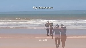 (TRECHO) Sarro gostoso interracial da howife. Esposa gostosa de biquini se exibe na praia e pega no pauzã_o do negã_o de sunga branca e recebe massagem na frente do corno.